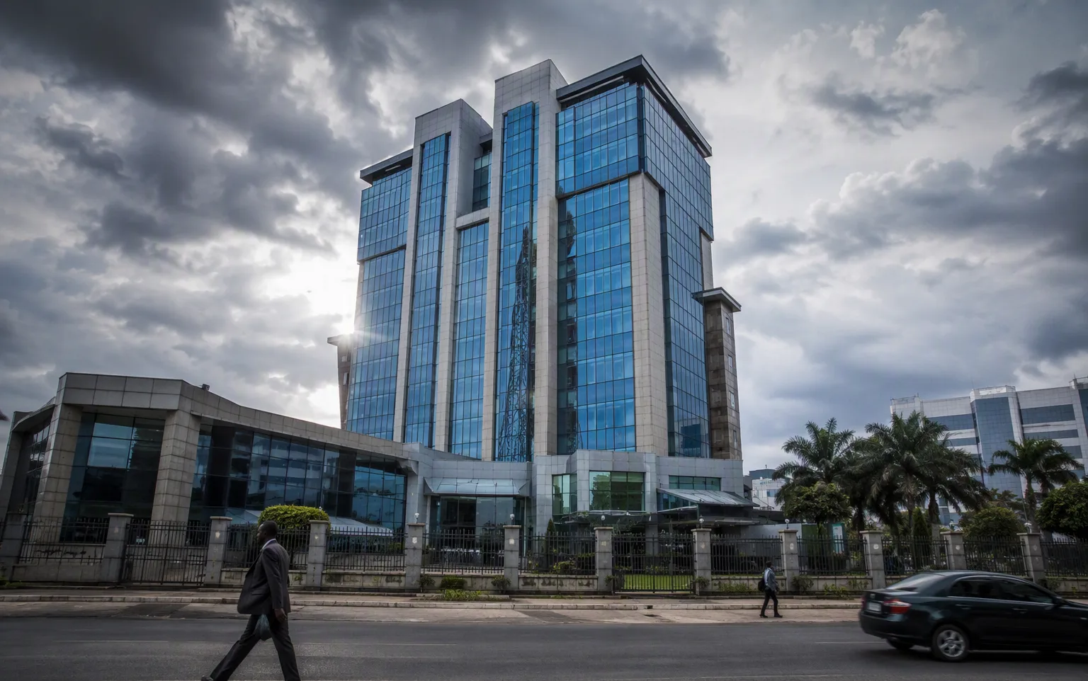 A central bank headquarters building under dramatic clouds