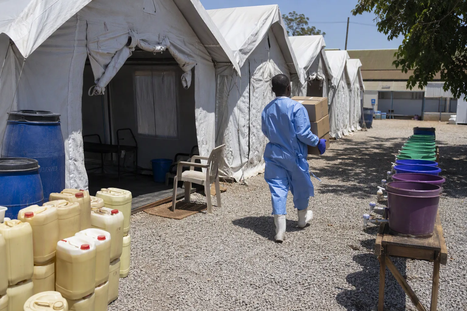 Cholera treatment tents on clinic grounds with water containers and chlorine drums