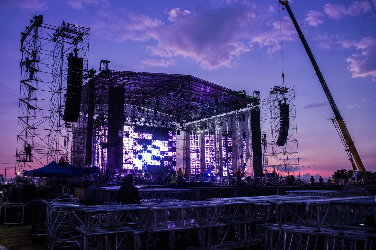 A concert stage under construction on a Lusaka polo field at dusk
