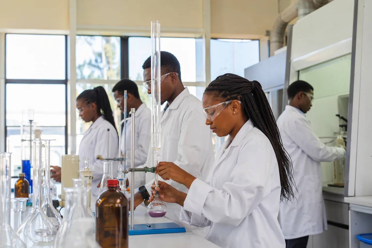 University students in lab coats working in a bright modern chemistry laboratory